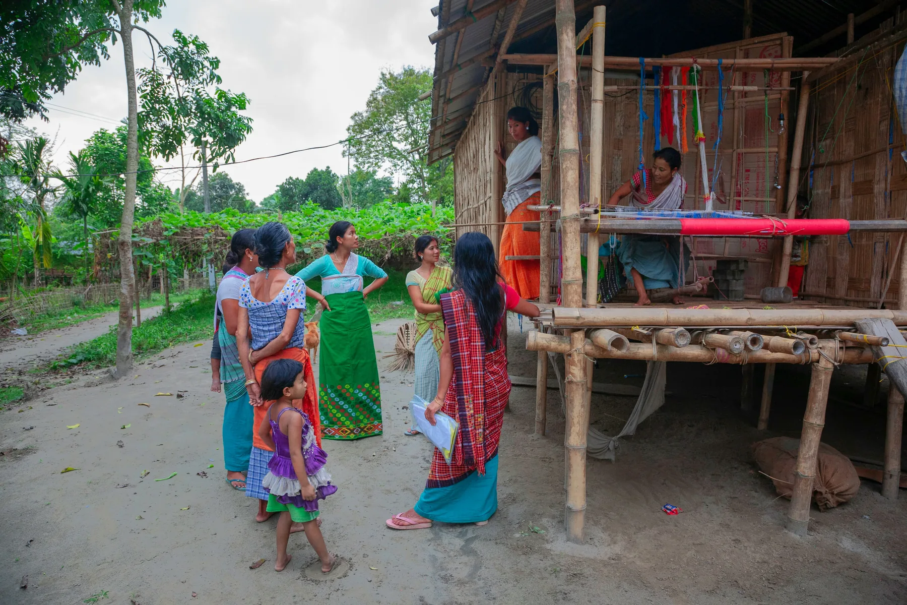 Women in a rural Indian community near a traditional loom
